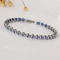 Detailed macro view of silver tennis bracelet with deep blue round-cut cubic zirconia stones - Steel Color/Deep Blue Zircon