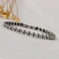 Macro shot of silver stainless steel chain bracelet with round black carbon fiber insets - Steel Color/Black Zircon