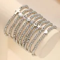 Set de 9 pulseras de cuentas plateadas con dijes de concha y cruz en un soporte - Estilo Con Múltiples Dijes / Juego De 9 / Plateado