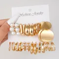 Dettaglio di un set da 17 orecchini dorati con perle e cerchi dal design a treccia - Combinazione di orecchini a bottone con perle artificiali dorate minimalista (5895101)