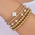 Detailansicht des 5-teiligen goldenen Perlenarmband-Sets mit weißem Kreuzanhänger - Elastische Filigrane Perlen (6324201HB)