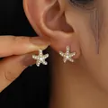 Élégantes boucles d'oreilles étoile de mer dorées avec perles blanches, vue portée - Étoile de Mer Pavée de Perles (6513701)