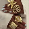 Set of vintage golden rings with textured floral design and pearls on model hand - Vintage Gold Pearl Ring Set (6393001HB)