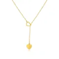 Macro detail of gold Y-shaped necklace featuring a hollow sliding heart and solid pendant - Heart Lariat Style (52510)