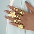 7er-Set goldene Ringe mit Perlen Seestern und Blumen an einer weiblichen Hand - Sonne Blumen Stil (6518601HB)