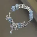 Elastic beaded bracelet featuring light blue crackle beads and silver butterfly charms - Blue and White Cracked Style with Butterfly (S425)