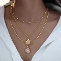 Detalle de un collar dorado de tres capas con perlas y colgante de flor usado por una modelo - 6502301hb