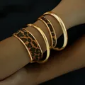 Primer plano de un set de cuatro pulseras doradas con diseño de estampado de leopardo - Juego de 4 Piezas de Leopardo Dorado (6543101HB)