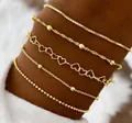 5-delige gouden armbandset met hartschakels en kralenkettingen op de pols gedragen - 5-delige gouden set (SH141-1)