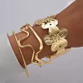 Primer plano del brazalete de flor dorada y pulseras geométricas onduladas en la muñeca - Juego de 3 Piezas de Flores y Ondas Dorado (6573901HB)