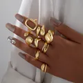 Macro shot of gold lava style irregular rings set on fingers with glossy finish - Nine-Piece Streamlined Liquid Metal Hollow Rectangle Ring Set (6573801HB)