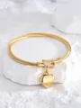 Vista ravvicinata del bracciale ritorto dorato con fibbia a ferro di cavallo e cuore - Oro