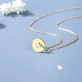Minimalistische gouden knoop ketting op blauwe ondergrond met witte droogbloemen - Goud
