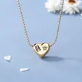 Collana cuore oro 18K con gemme rosa e verdi su sfondo blu elegante e raffinato - Oro