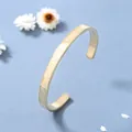 Vista dettagliata del bracciale aperto dorato con finitura spazzolata e numeri romani - Oro