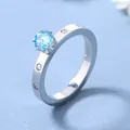 Detailansicht eines Titanstahlrings mit hellblauem Edelstein in einer Vier-Krallen-Fassung - US 6 / Himmelblau