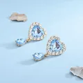 Dettaglio macro di orecchini a cuore in cristallo azzurro con finitura in strass - Azzurro