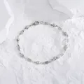 Dettaglio macro della catena in titanio argento con cuore lucido e chiusura a moschettone - Bracciale