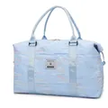 Light blue quilted travel bag with colorful embroidery and sturdy webbed handles - Light Blue