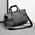 Dark grey large travel duffel bag with waterproof matte finish and orange accent details - Gray