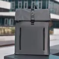 Minimalist grey roll-top backpack with waterproof fabric and vertical zipper pockets - Gray