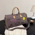 Grote donker koffiekleurige canvas reistas met kleurrijke graffiti en lederen handvatten - Bruin