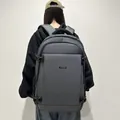 Deep grey water-resistant business backpack worn by model showing large capacity and fit - Gray