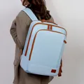 Light blue large capacity travel backpack with brown leather trim shown on model - Blue