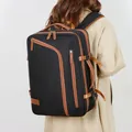 Black travel backpack with tan leather trim and side buckles worn by a model - Black