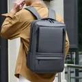 Dark grey waterproof laptop backpack for business travel shown on a model - Gray