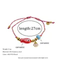 Detail of woven bracelet with ceramic fish, shell charm, and PVD gold plating measurements - Red Fish Style (MSB0476)