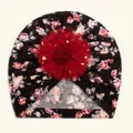 Detail der Baby-Blumenturban-Mütze mit roter Netzblume und goldenen Stern-Pailletten - Schwarz
