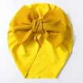 Gros plan détaillé du bonnet turban jaune pour bébé avec un grand nœud décoratif - Jaune