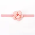 Dettaglio del fiore di camelia in tessuto rosa e fascia elastica per neonata - Gemma di Neve