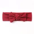 Close-up of the textured burgundy knit fabric and knotted bow detail on a baby headband - Burgundy