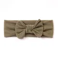 Detailed view of olive green ribbed knit baby headband with 3D decorative bow accent - Dark Green