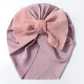 Details von Baby-Turbanmütze aus fliederfarbenem Rippstrick mit großer rosa Chiffonschleife - Altrosa