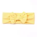 Soft light yellow baby headband with decorative knotted bow on a white background - Beige