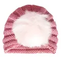 Dettaglio di un cappello in maglia rosa per neonati con trama a coste e grande pompon di pelliccia - Taglia unica / Rosa pelle