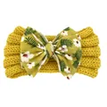 Détail du bandeau tricoté jaune pour bébé avec un grand nœud à imprimé floral doux - Jaune