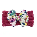 Détail du bandeau bébé avec texture en maille rose foncé et gros nœud à motif floral - Rose rouge