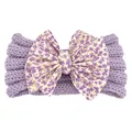 Détail d'un bandeau bébé en tricot violet orné d'un grand nœud à imprimé fleuri - Violet