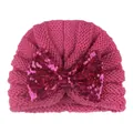 Détail du bonnet bébé en tricot rose fuchsia avec un grand nœud en paillettes brillantes - Rose rouge