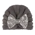Détails de la maille et nœud en paillettes argentées sur ce bonnet d'hiver bébé - Gris
