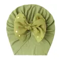 Detail of moss green ribbed knit baby turban featuring a large gold polka dot bow - Green
