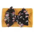 Vue détaillée d'un bandeau bébé en nylon jaune avec un grand nœud à fleurs - Jaune Terre