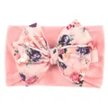 Détail d'un bandeau bébé en nylon rose avec un grand nœud à imprimé floral vintage - Rose