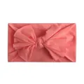 Detailopname van zachte koraalroze nylon hoofdband met een grote strik voor baby's - Watermeloen Rood