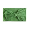 Detail van de grasgroene nylon textuur en grote strik op de zachte baby hoofdband - Groen