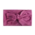 Macro-opname van diep magenta nylon baby hoofdband met een grote zachte strik - Donkerpaars